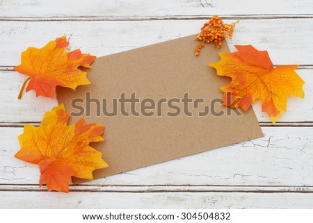 Blank Card for your fall message, A brown card that is blank over a distressed wood background with autumn leaves