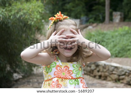 Cute girl playing with hands over eyes