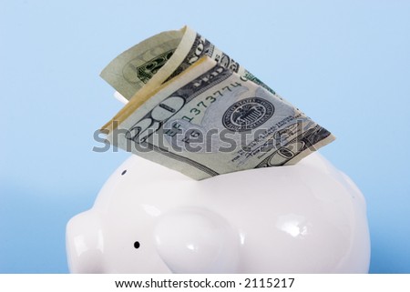 Putting a twenty dollar bill - money in a piggy bank