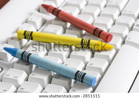 close-up of a computer white keyboard with crayons for a background