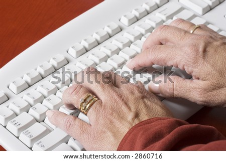 close-up of a computer white keyboard with woman typing