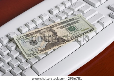 close-up of a computer white keyboard with twenty dollar bill - online transactions