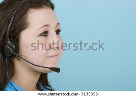 A woman with headset smiling on a blue background with copy space