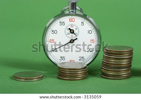 A row on coins with increasing value with a stop watch
