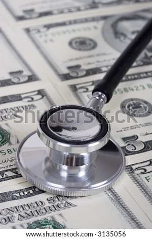 Stethoscope on money background of five dollar bills