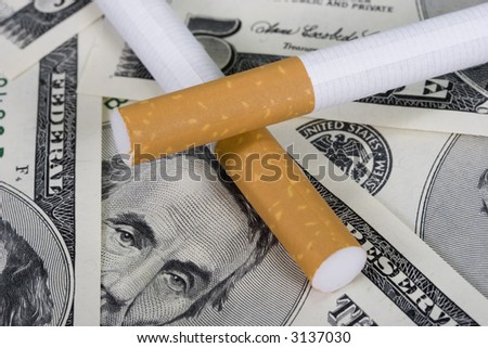 Two cigarettes with five dollar bill background