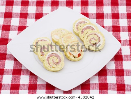 Party food on a white square plate with a red checked tablecloth