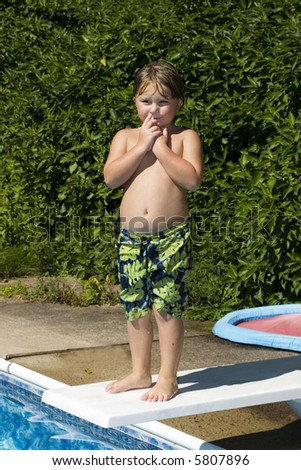 Young boy getting ready to jump from diving board