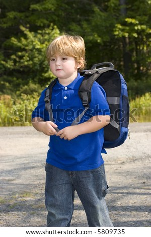 Young boy waiting for the school bus on first day of school