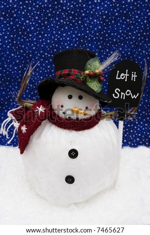Snowman on night sky background holding a sign