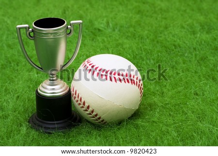 Baseball and trophy on grass with copy space