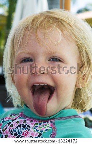Playful little girl sticking out her tongue