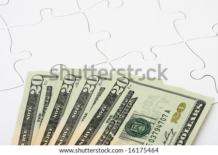 Puzzle with twenty dollar bills sitting on it. understanding finances