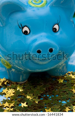 Blue piggy bank sitting on gold star background, great investments