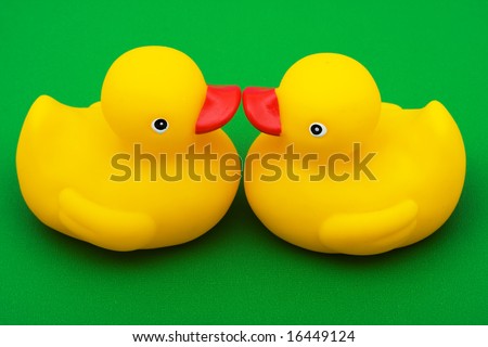 Two rubber ducks on green background, rubber ducks