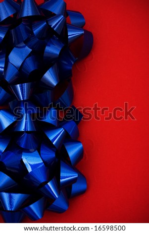 Blue plastic bows on red background making a border, blue bow border