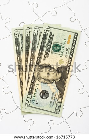 Puzzle with twenty dollar bills sitting on it. understanding finances