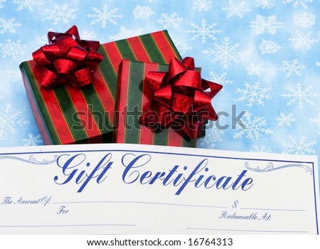 Two red and green striped wrapped presents with gift certificate on snowflake background, Christmas presents