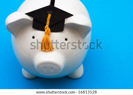 Piggy bank with graduation cap on blue background, saving for college