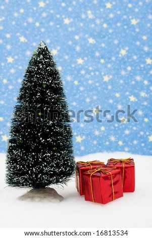 Three red Christmas presents under tree on snow with star background, Christmas presents