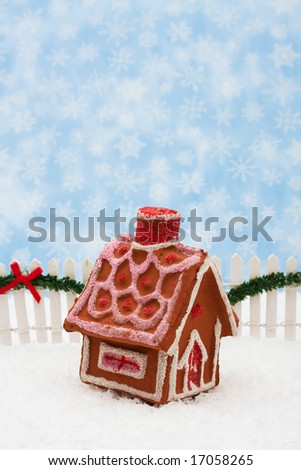 Gingerbread house and white picket fence with green garland and red bow, merry Christmas