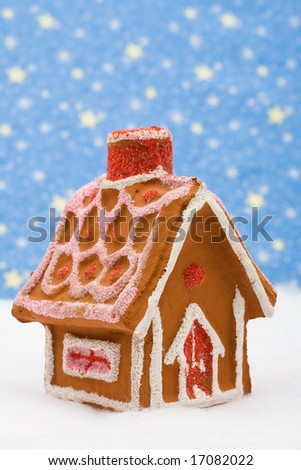 Gingerbread house on snow with star background, gingerbread house