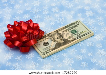 Twenty dollar bills with red bow on it on snowflake background, gift of money