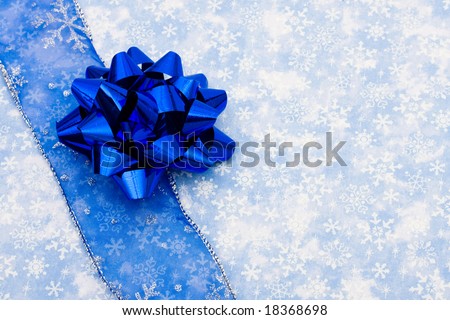 Blue ribbon and bow on a snowflake background, happy holidays