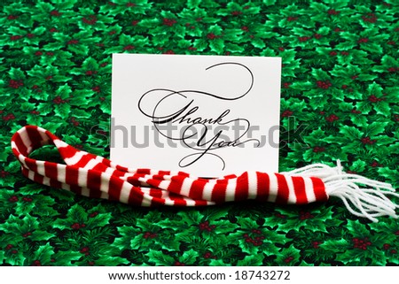 Thank you card and striped scarf on leaf and holly berry background, thank you card