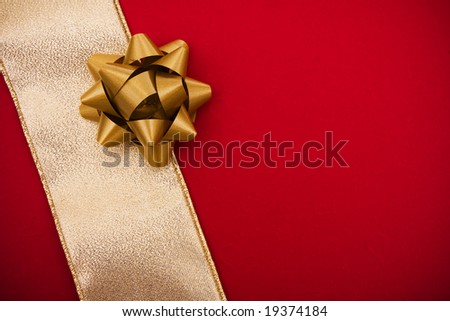 Gold ribbon on red background with bow making a present