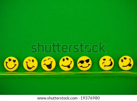 Row of happy faces on green background, happy faces