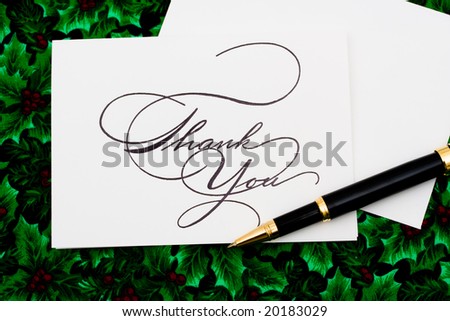 Thank you card and pen on leaf and holly berry background, thank you card
