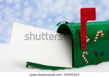 Green mailbox with blank card and the flag up sitting on snow with a snowflake background, mailbox