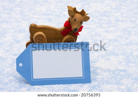 Blank card with wooden reindeer on blue snowflake background, happy holidays