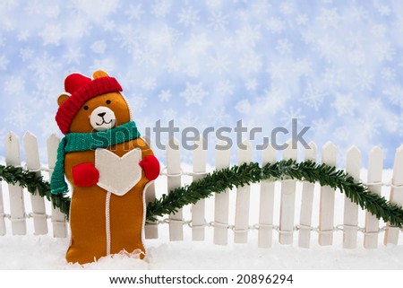 Stuffed bear with white fence and green garland on snowflake background, Christmas bears