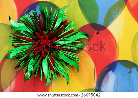 A green and red ribbon bow sitting on a colourful balloon background, green and red bow, birthday present