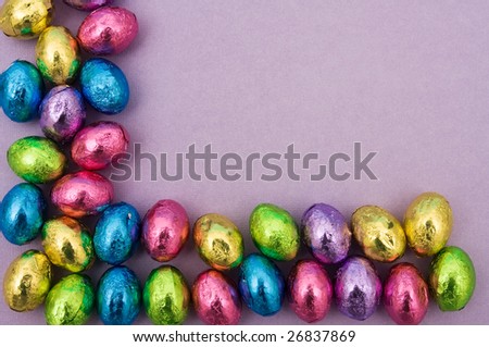 Foil covered Easter eggs making a border on a purple background, Easter border