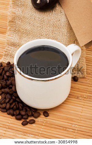 Burlap bag filled with coffee sitting on a wooden background, coffee bag