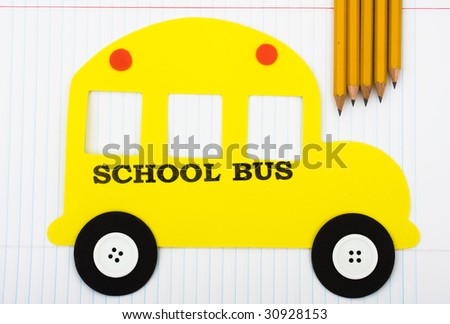 A yellow school bus with wooden pencils sitting on a paper background, School days