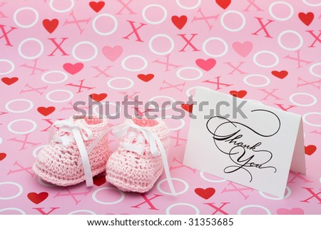 A white thank you card with baby booties on a pink love background, thank you note