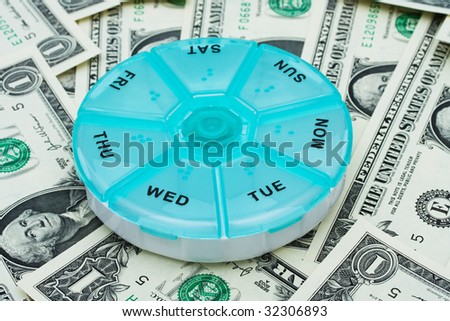 Daily pill holder sitting on one dollar bill background, Costs of medication