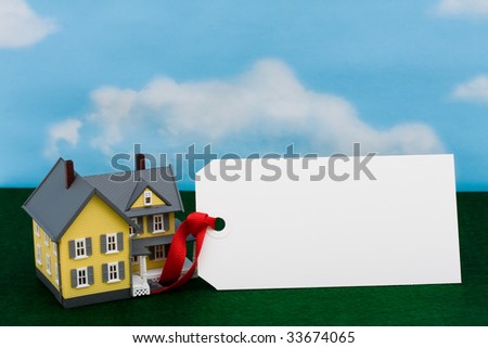 A model house sitting with blank tag on a sky background, housing prices