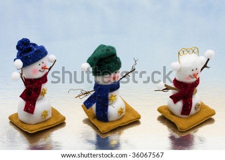 Three snowman sitting together on a icy background, happy holidays