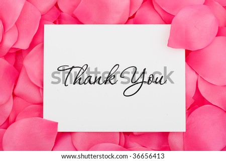 A thank you card sitting on a pink flower petal background, thank you with love