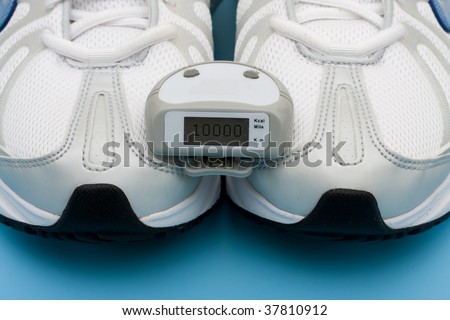 A pair of sneakers and a pedometer on a blue background, walking for a healthy heart