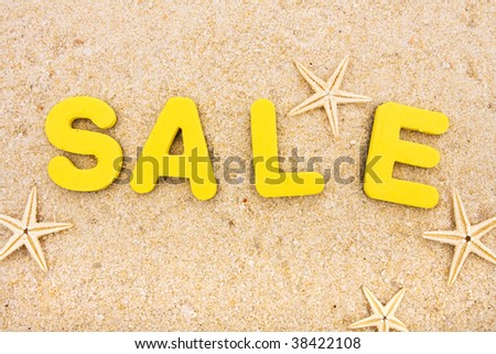 The word sale sitting on a beach with starfish, vacation money