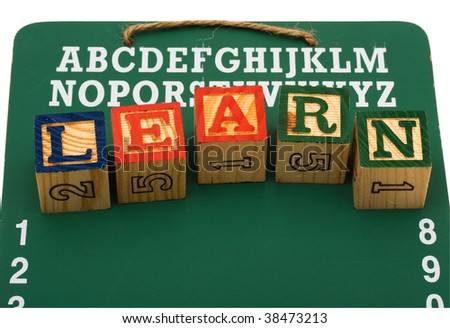 A green chalk board with the word learn spelled with blocks isolated on a white background, back to school