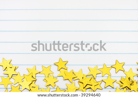 Gold stars making a border on a lined paper background, gold star border