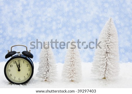 White evergreen trees sitting with a black retro clock on snow with a blue snowflake background, winter time