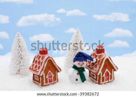 Two gingerbread houses sitting on a snow background, gingerbread houses